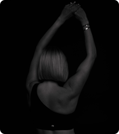 Black and white image of a woman stretching both arms